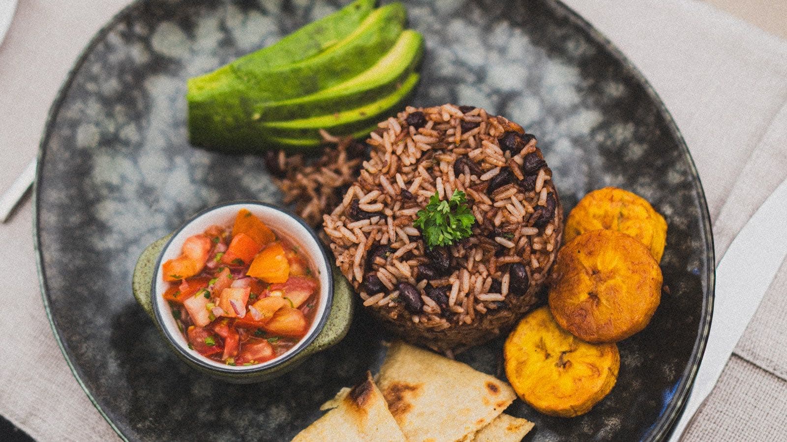Costa Rican gallo pinto plate with rice, black beans, avocado, plantain, and fresh salsa
